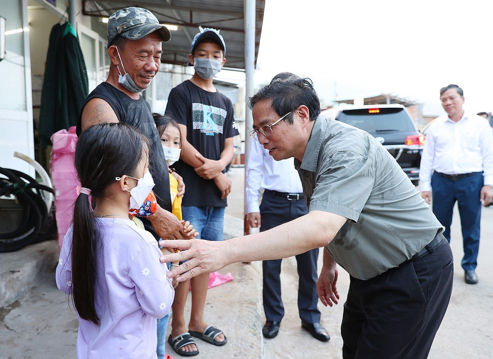Thủ tướng Phạm Minh Chính thăm hỏi, động viên gia đình người dân tại cảng cá xã Cà Ná, huyện Thuận Nam. (Ảnh: Dương Giang/TTXVN)