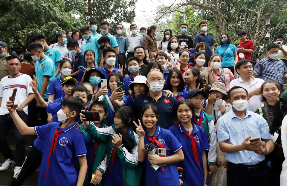 Lãnh đạo Liên đoàn bóng đá Việt Nam, Ban huấn luyện cùng các cầu thủ Đội tuyển bóng đá U23 chụp ảnh lưu niệm với du khách về dâng hương tại Đền Hùng. (Ảnh: Trung Kiên/TTXVN)