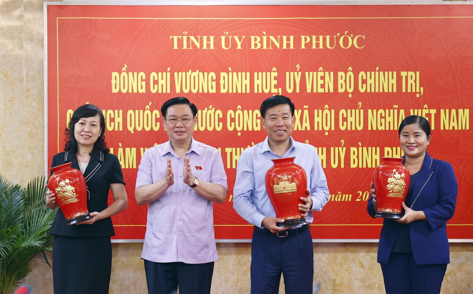 Chủ tịch Quốc hội Vương Đình Huệ tặng vật phẩm lưu niệm cho các cán bộ trong Ban Thường vụ Tỉnh ủy Bình Phước. (Ảnh: Doãn Tấn/TTXVN)