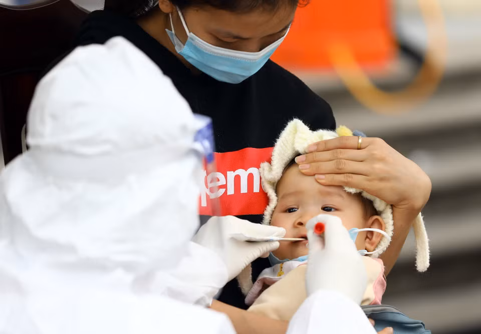 Lấy mẫu xét nghiệm cho một cháu nhỏ tại phường Yên Hòa (Cầu Giấy). (Ảnh: Huy Hùng/TTXVN)