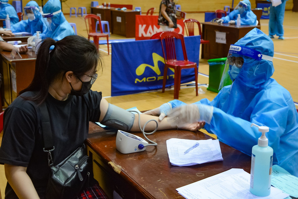 Nhân viên y tế khám sàng lọc trước khi tiêm vaccine phòng COVID-19. (Ảnh: Văn Dũng/TTXVN)