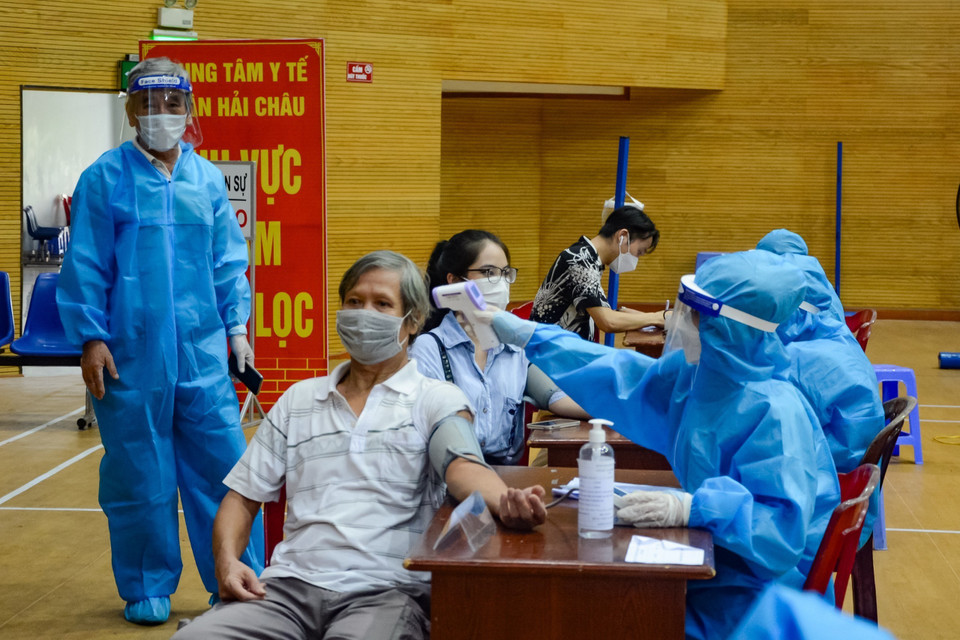 Nhân viên y tế khám sàng lọc trước khi tiêm vaccine. (Ảnh: Văn Dũng/TTXVN)