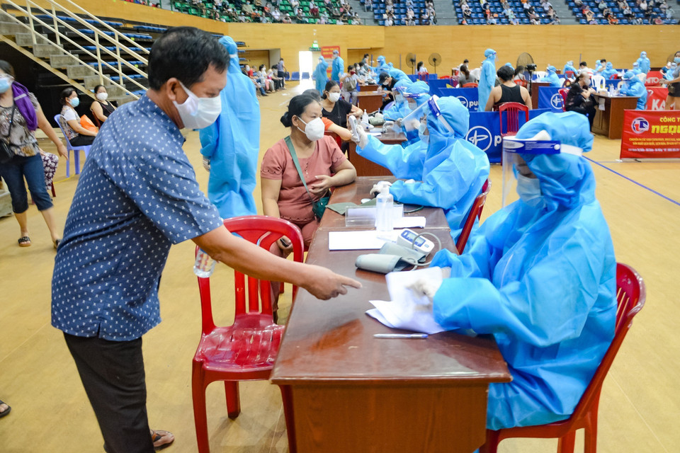 Nhân viên y tế khám sàng lọc trước khi tiêm. (Ảnh: Văn Dũng/TTXVN)