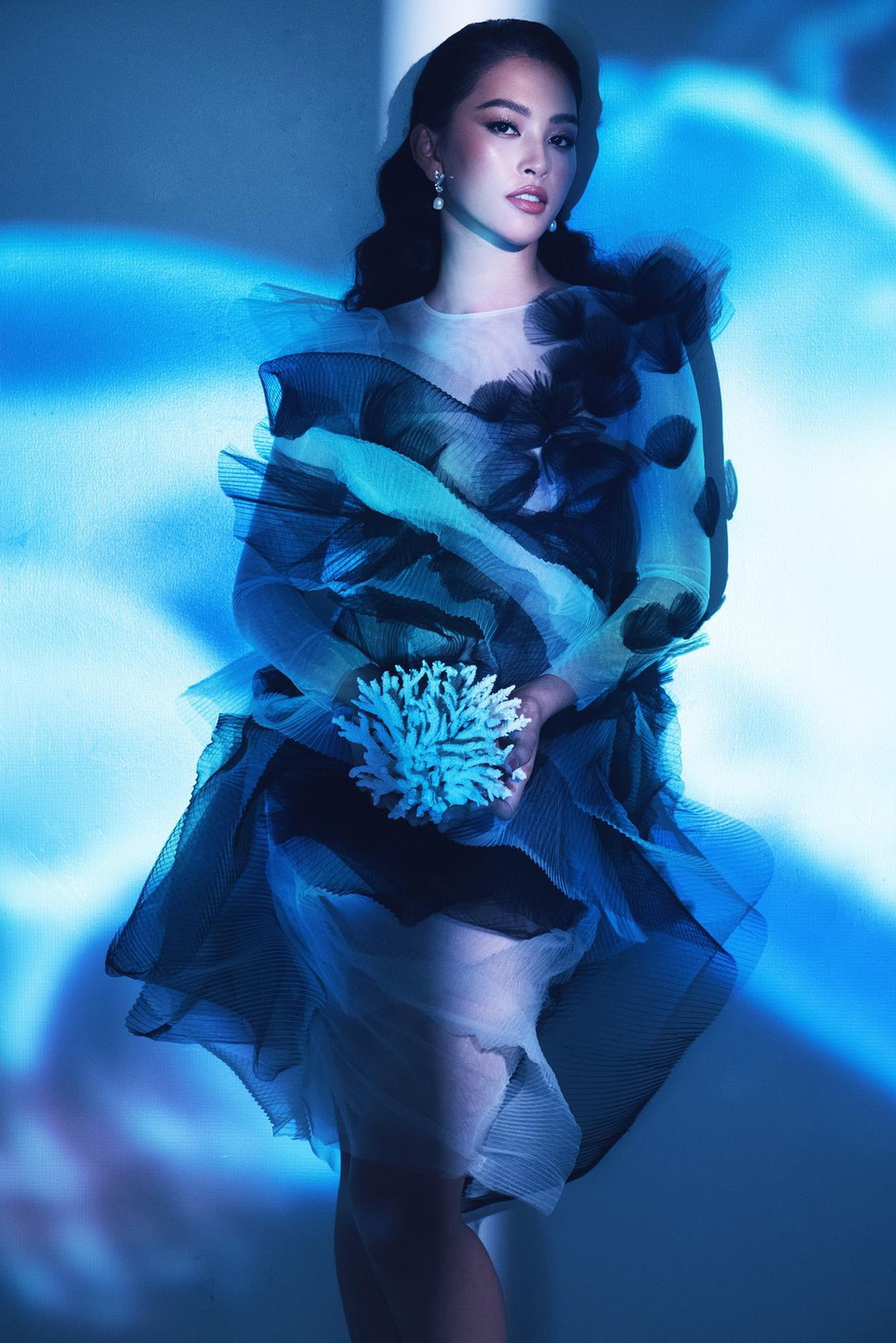 Không chỉ vậy, những xử lý về mặt chất liệu, kỹ thuật đính kết tạo hình san hô, sinh vật biển bằng những chất liệu mang tính thời trang, các dáng tay áo được dựng phom nhọn, các chi tiết phối khung như một bộ giáp mạnh mẽ đã giúp Tiểu Vy và Đỗ Mỹ Linh toát lên vẻ mạnh mẽ của nữ thần đại dương. (Ảnh: Milor Trần) 