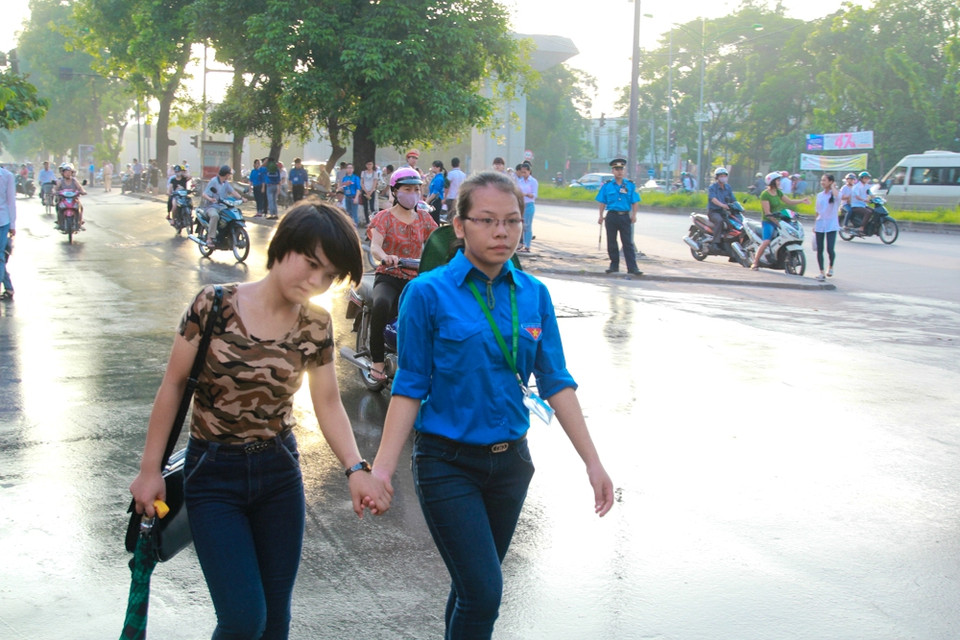 Tình nguyện viên dẫn một thí sinh thi Đại học Khoa học xã hội và Nhân văn nhưng đi lạc sang điểm trường Đại học Khoa học tự nhiên. (Ảnh: Minh Sơn/Vietnam+)