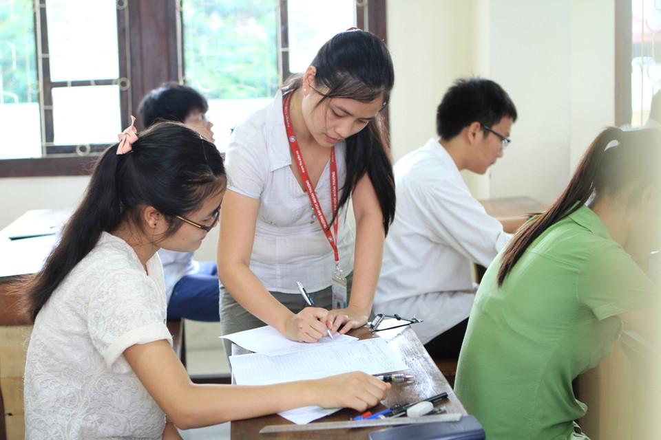 Giám thị ký xác nhận giấy thi. (Ảnh: Xuân Mai/Vietnam+)