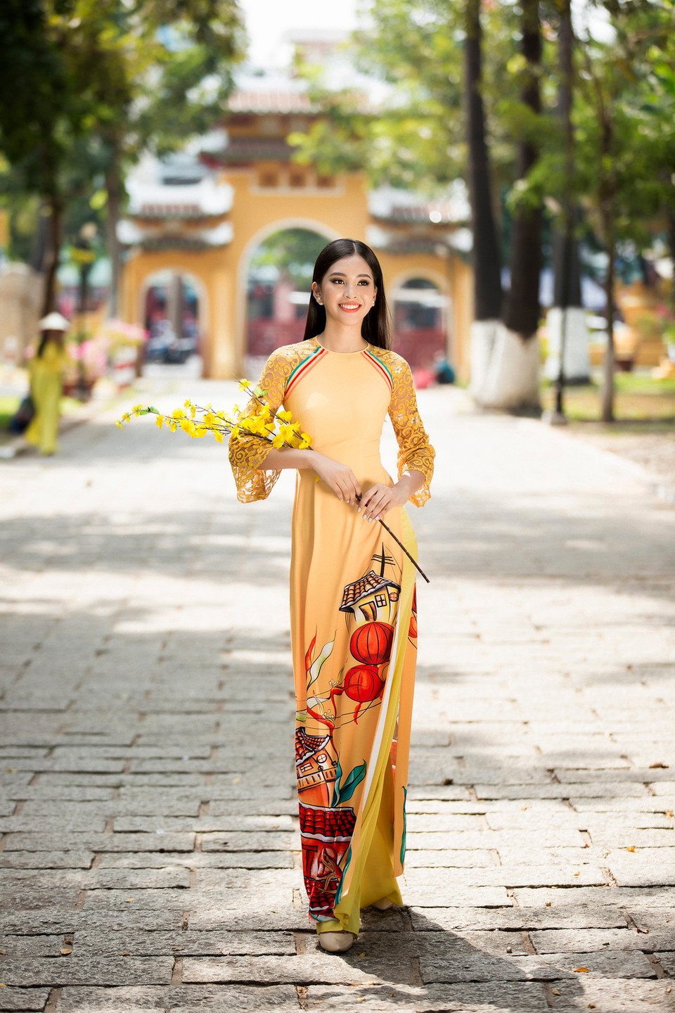 Bộ sưu tập áo dài ‘Mơ Xuân’ lấy ý tưởng từ ký ức tuổi thơ của Hoa hậu với những vách ngói cổ Hội An, cành mai đào, lồng đèn đỏ một thuở Xuân xưa. (Ảnh: Lê Thiện Viễn/Vietnam+)