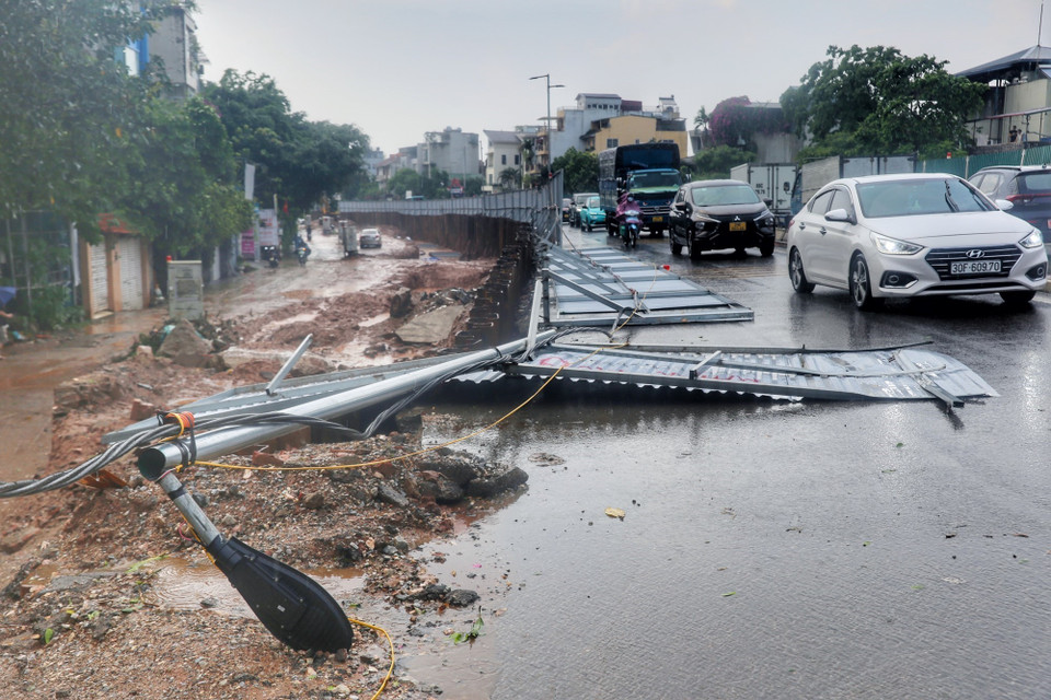 Một phần hàng rào trên phố Âu Cơ bị đổ do gió mạnh gây nguy hiểm cho người tham gia giao thông. (Ảnh: Tuấn Đức/TTXVN)