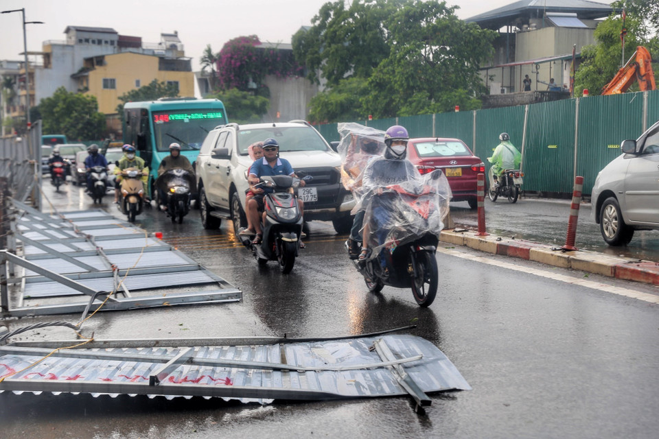 Một phần hàng rào trên phố Âu Cơ bị đổ do gió mạnh gây nguy hiểm cho người tham gia giao thông. (Ảnh: Tuấn Đức/TTXVN)