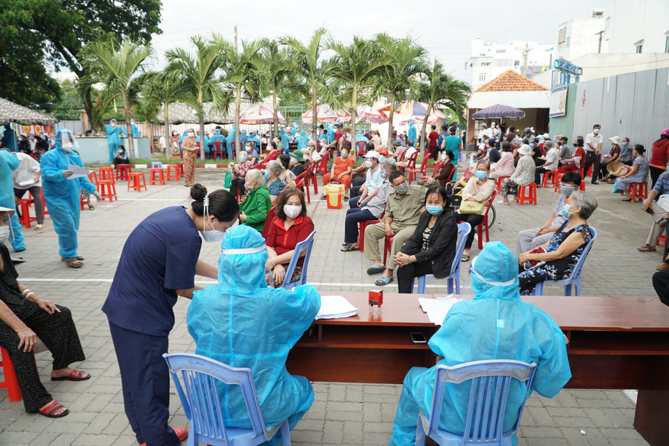 Nhân viên y tế hỗ trợ người dân tra cứu thông tin trước khi thực hiện tiêm chủng tại điểm tiêm UBND phường 9 (quận Gò Vấp, Thành phố Hồ Chí Minh). (Ảnh: Thu Hương/TTXVN)