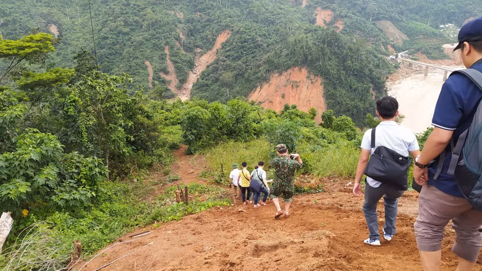 Lực lượng cứu hộ băng rừng Phước Lộc để tiếp cận xã Phước Sơn. (Ảnh: Quốc Dũng/TTXVN)