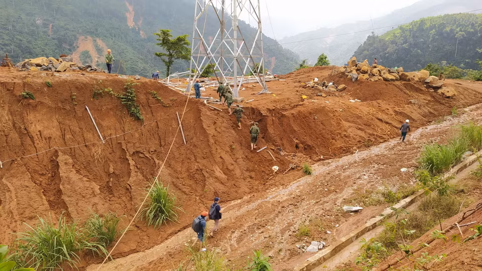 Lực lượng cứu hộ băng rừng Phước Lộc để tiếp cận xã Phước Sơn. (Ảnh: Quốc Dũng/TTXVN)