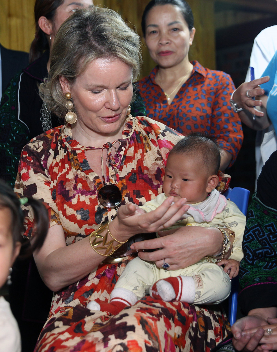Hoàng hậu Vương quốc Bỉ Mathilde bế một em bé. (Ảnh: Quốc Khánh/TTXVN)