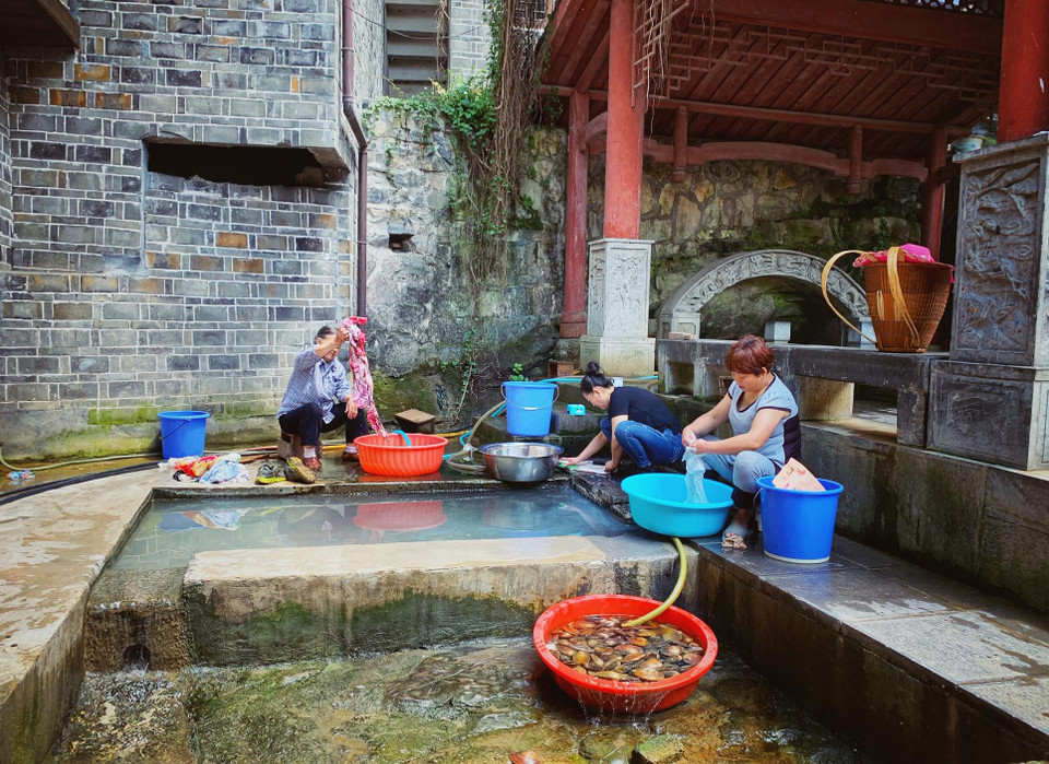 Người dân trong làng vẫn giữ nếp sinh hoạt truyền thống với việc tận dụng nguồn nước suối giặt giũ, rửa đồ. (Ảnh: Xuân Mai/Vietnam+)