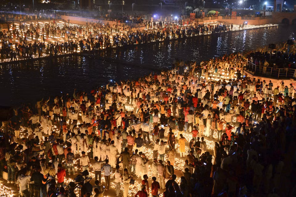 Người dân thắp đèn dầu bên bờ sông Sarayu ở Ayodhya, Ấn Độ, trước thềm lễ hội ánh sáng Diwali, ngày 26/10/2019. (Ảnh: AFP/TTXVN)