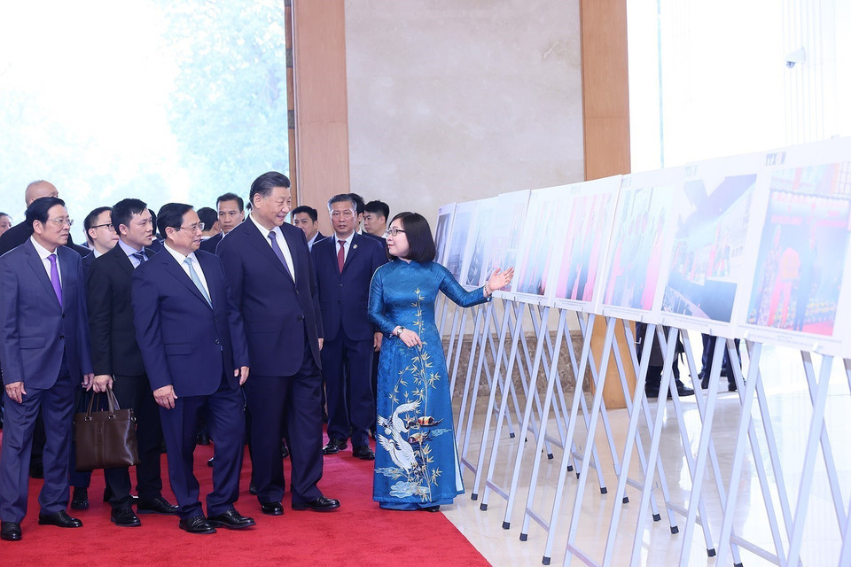 Phó Tổng Giám đốc TTXVN Đoàn Thị Tuyết Nhung giới thiệu với Thủ tướng Phạm Minh Chính và Tổng Bí thư, Chủ tịch nước Trung Quốc Tập Cận Bình những hình ảnh tiêu biểu về quan hệ hai nước. (Ảnh: Dương Giang/TTXVN)