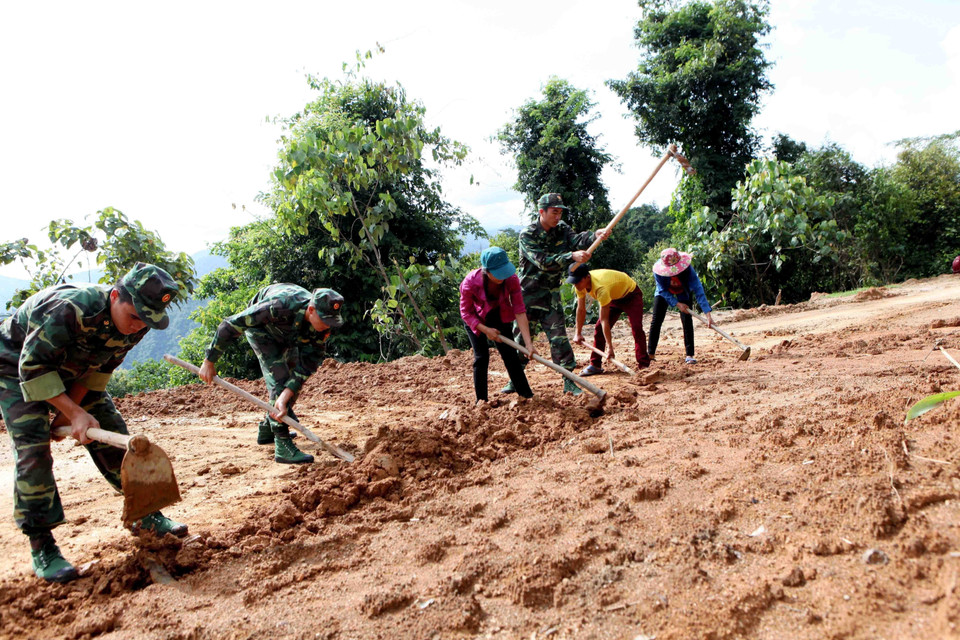 Cán bộ, chiến sỹ Bộ đội Biên phòng Lai Châu cùng bà con nhân dân mở đường vào bản. (Ảnh: Công Tuyên/TTXVN)