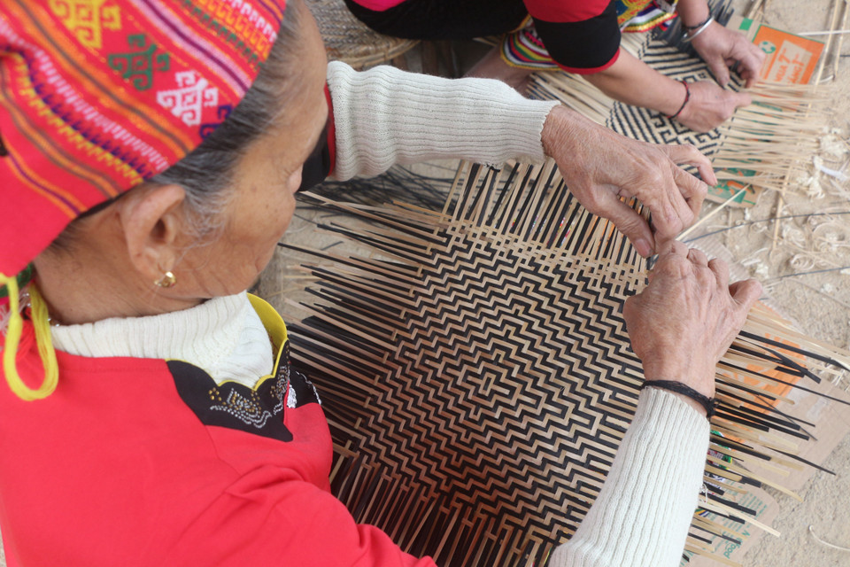 Đan các sản phẩm mây tre. (Ảnh: Bích Huệ/TTXVN)