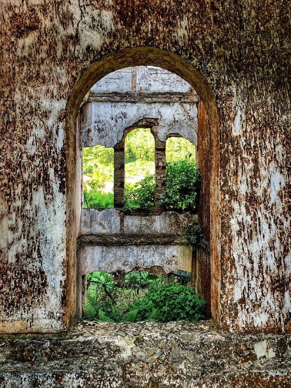 Từng mảng tường, ô cửa sổ phủ lớp rêu dày nhưng vẫn vô cùng kiên cố. Dấu ấn thời gian in đậm trên mỗi bờ tường, viên gạch… (Ảnh: Xuân Mai/Vietnam+)