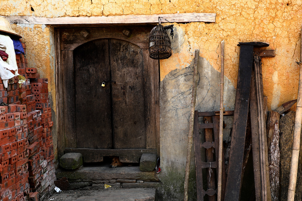 Dưới mỗi cửa chính đều khoét một lỗ lớn cho các vật nuôi trong nhà ra vào dễ dàng. (Ảnh: Xuân Mai/Vietnam+)