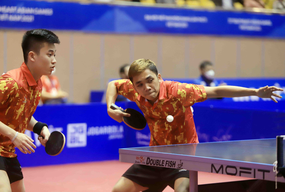 Pha phát bóng của vận động viên số 53 Đinh Anh Hoàng (Việt Nam, áo đỏ) trong trận đối đầu với vận động viên số 7 Leong Chee Feng và vận động viên số 10 Danny NG Wann Sing (Malaysia, áo đen). (Ảnh: Quý Trung/TTXVN)