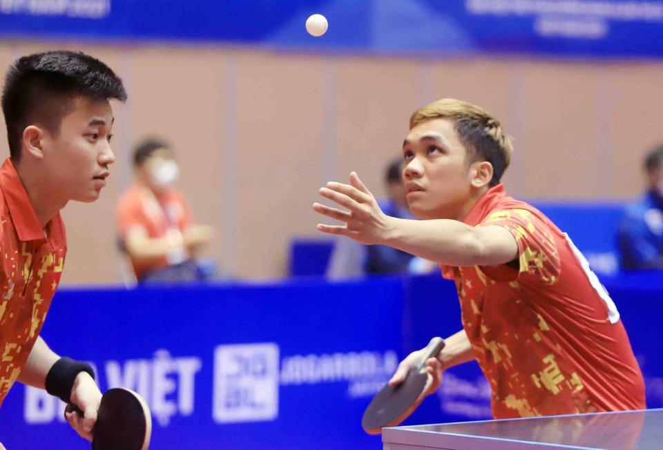 Pha phát bóng của vận động viên số 53 Đinh Anh Hoàng (Việt Nam, áo đỏ) trong trận đối đầu với vận động viên số 7 Leong Chee Feng và vận động viên số 10 Danny NG Wann Sing (Malaysia, áo đen). (Ảnh: Quý Trung/TTXVN)