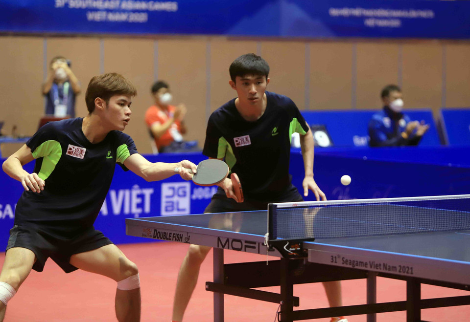 Pha phòng thủ của vận động viên số 10 Danny NG Wann Sing (Malaysia, áo đen) khi đối đầu với cặp đôi số 52 Lê Đình Đức và số 53 Đinh Anh Hoàng (Việt Nam, áo đỏ). (Ảnh: Quý Trung/TTXVN)