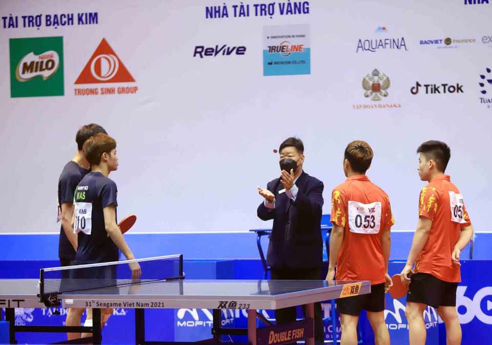 Trọng tài làm thủ tục trước khi bước vào trận nội dung đôi nam, cặp đôi số 52 Lê Đình Đức và số 53 Đinh Anh Hoàng (Việt Nam, áo đỏ) đối đầu với vận động viên số 7 Leong Chee Feng và vận động viên số 10 Danny NG Wann Sing (Malaysia, áo đen). (Ảnh: Quý Trung/TTXVN)