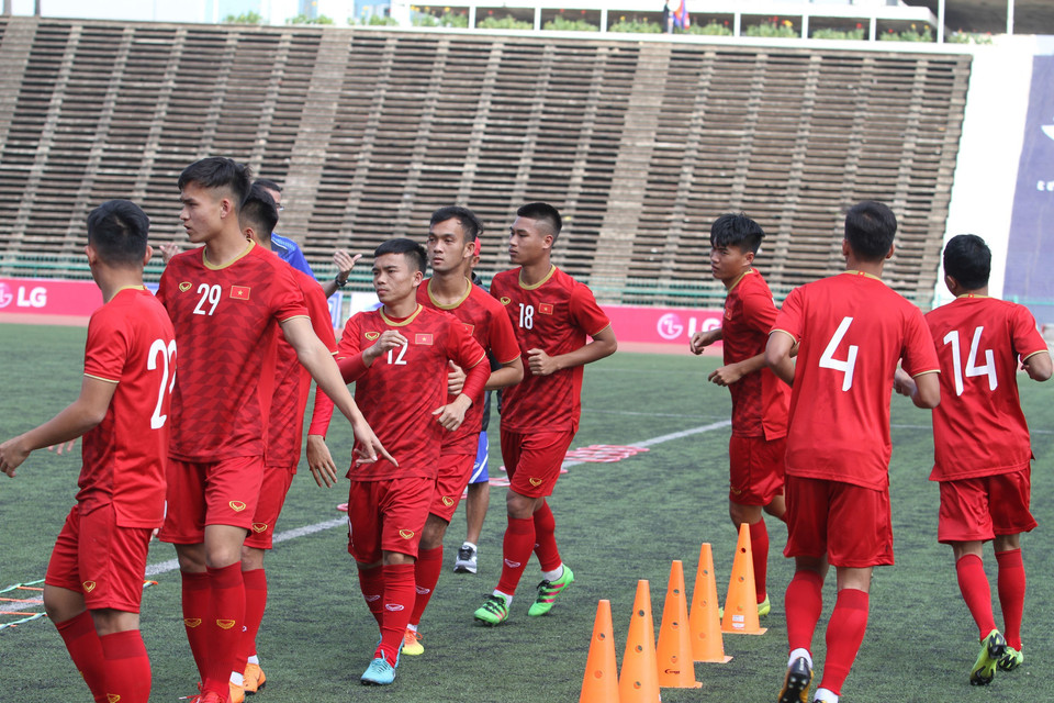 Cầu thủ U22 tập các bài khởi động. (Ảnh: Hoàng Linh/TTXVN)