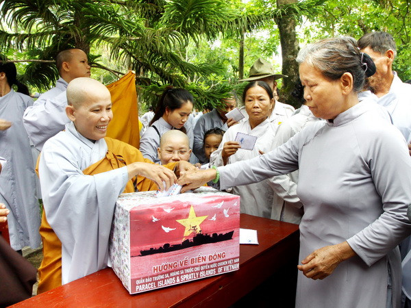  Các tăng ni, phật tử đóng góp ủng hộ chương trình "Nghĩa tình Hoàng Sa, Trường Sa." (Ảnh: Hồ Cầu/TTXVN)