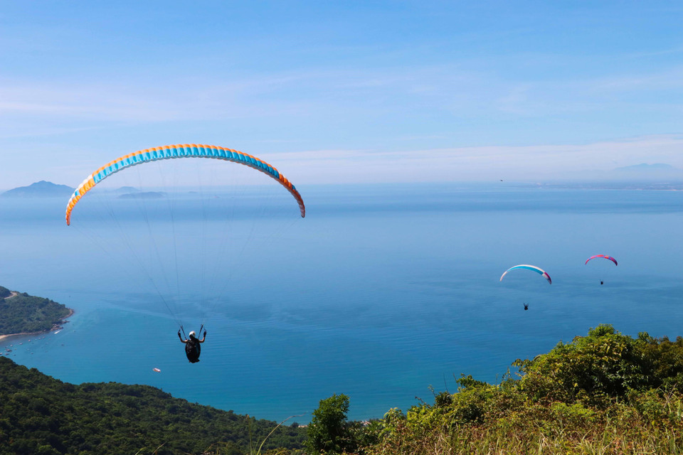 Các vận động viên biểu diễn lượn dù sau khi xuất phát. (Ảnh: Trần Lê Lâm/TTXVN)