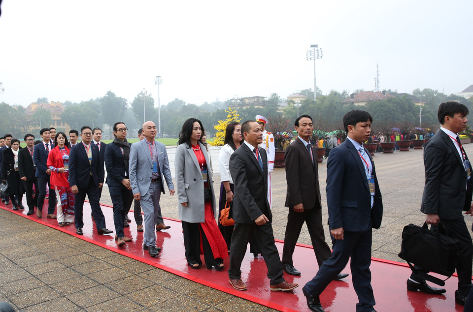 Đoàn kiều bào tiêu biểu dự chương trình 'Xuân quê hương' đặt vòng hoa và vào Lăng viếng Chủ tịch Hồ Chí Minh. (Ảnh: Dương Giang/TTXVN)