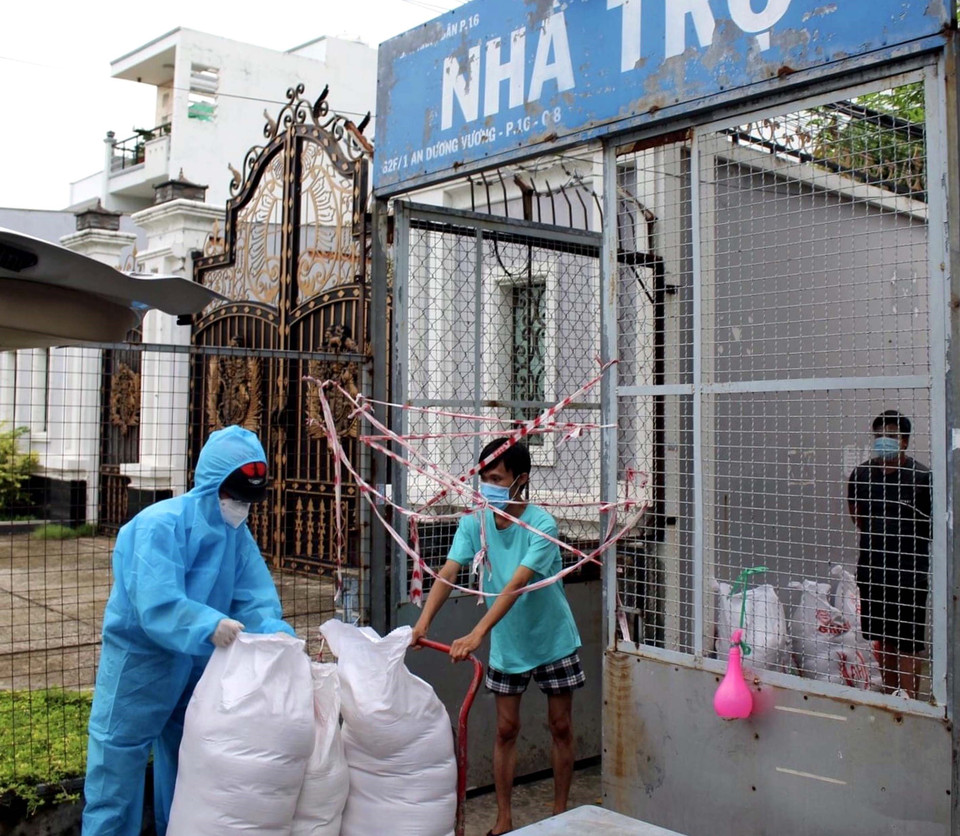 Đại diện Liên đoàn Lao động quận 8 trao quà cho công nhân ở trọ, người nghèo trong khu phong tỏa. (Ảnh: TTXVN phát)