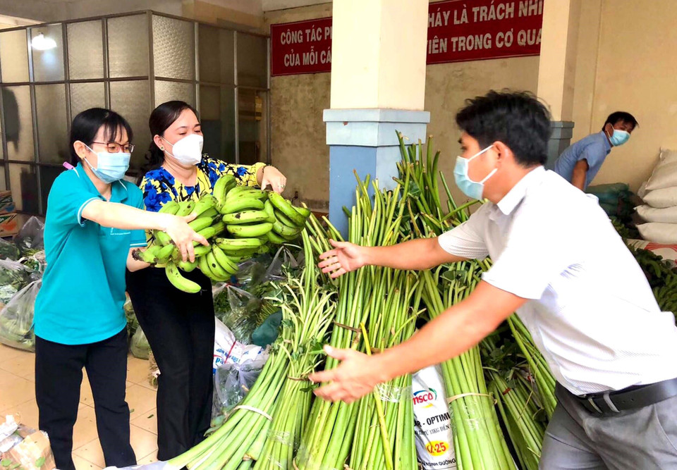 Hội Nông dân và Công đoàn viên chức Thành phố tiếp nhận và vận chuyển nông sản, lương thực, thực phẩm gửi đến công nhân, người nghèo trong khu phong tỏa và lực lượng trực chốt. (Ảnh: Thanh Vũ/TTXVN)