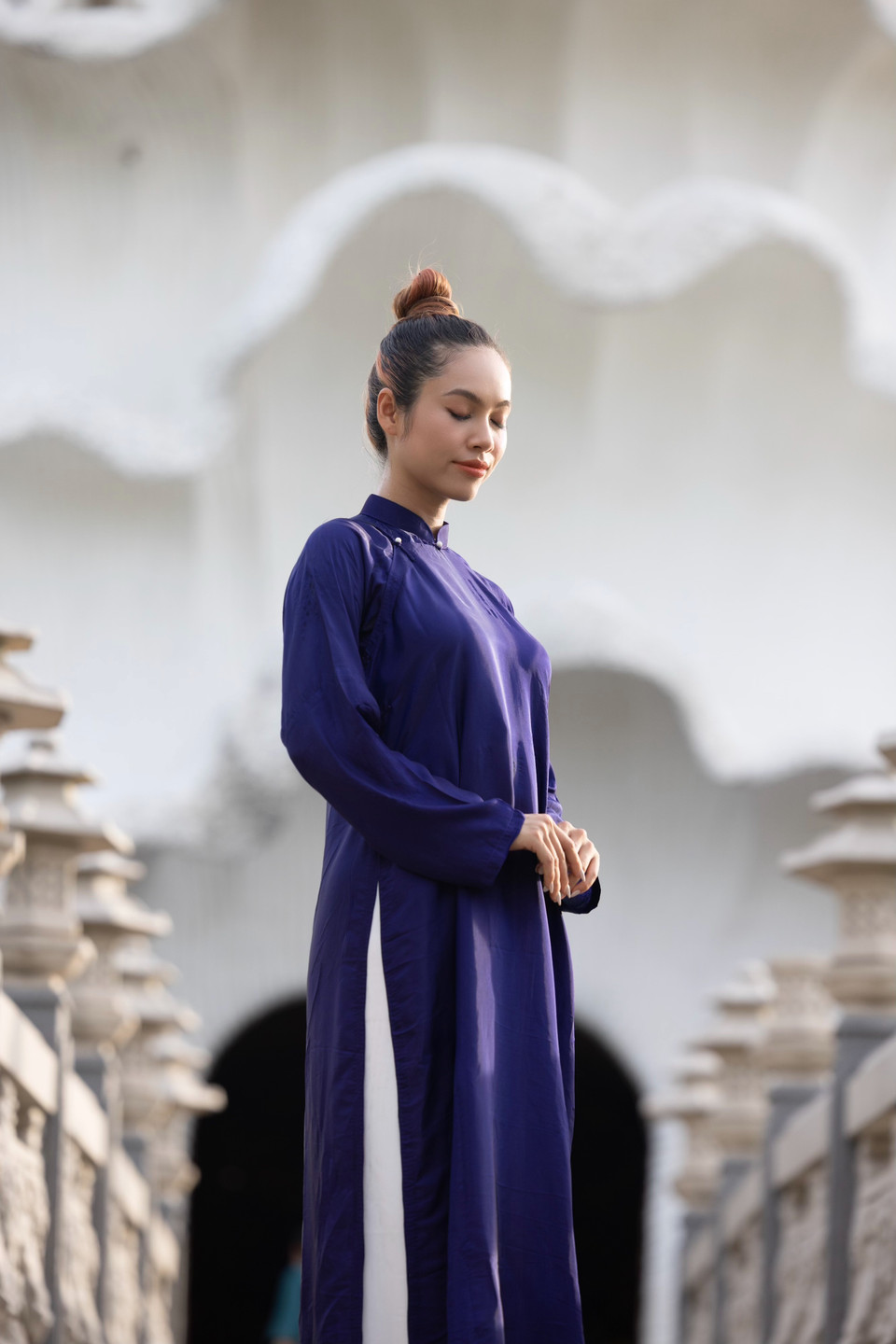 Tương truyền, chùa Gò Kén trước đây chỉ là một mái chùa nhỏ bé nằm giữa cánh đồng. Nhưng đến ngày nọ, một vị tu hành trong khi thiền xuất hồn đã thấy mình đến đây. Sau đó, ông liền tìm đến tu hành và bắt đầu xây dựng ngôi chùa bằng những vật liệu rất thô sơ. Đến nay, ngôi chùa được xây dựng nguy nga tráng lệ với kiến trúc ấn tượng, là một trong những ngôi chùa linh thiêng ở Tây Ninh. Đó là lý do Hoàng My chọn cho mình chiếc áo dài tím đơn sắc, nhã nhặn, dịu dàng khi thực hiện loạt ảnh tại Chùa Thiền Lâm. (Ảnh: CTV/Vietnam+)