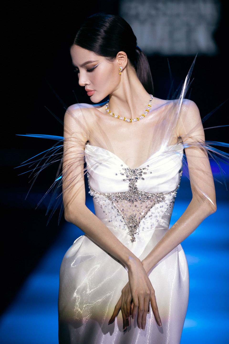 Bằng việc tái chế nhựa dẻo trở thành những chi tiết lấp lánh được đính kết trên váy, Hoàng Minh Hà vừa hòa chung làn sóng thời trang bền vững, vừa tôn vinh nét đẹp của người phụ nữ, khắc họa họ như những hạt bụi vàng lấp lánh giữa làn nắng thời trang. (Ảnh: CTV/Vietnam+)