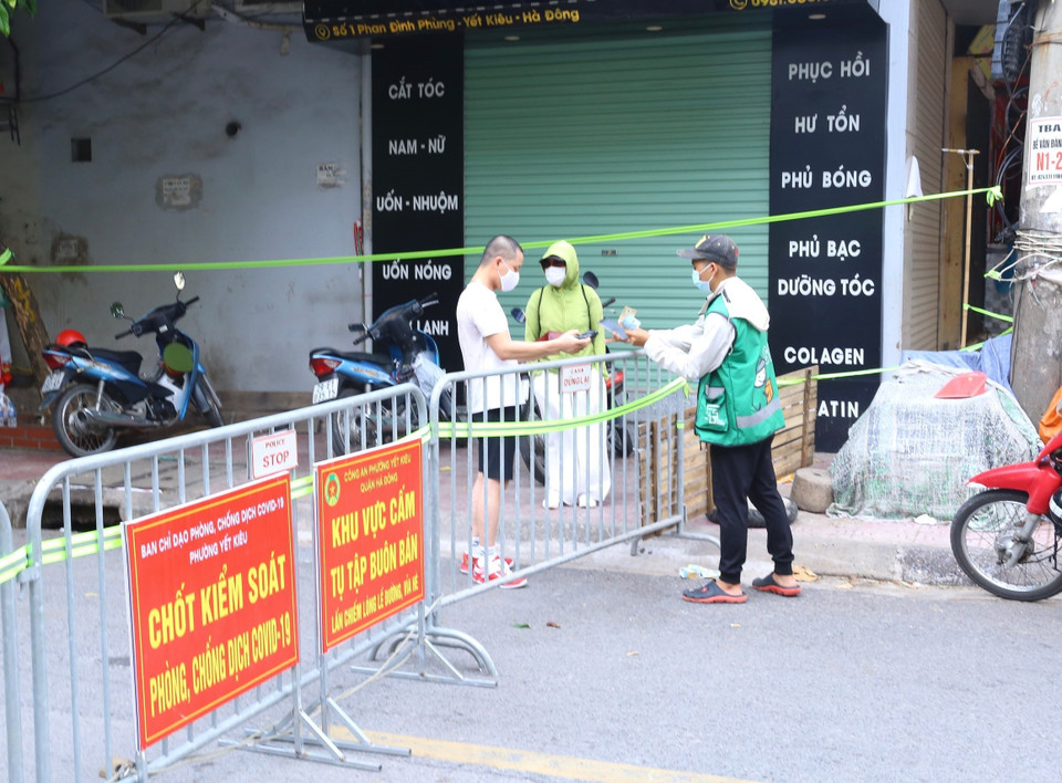 Giao nhận hàng tại rào chắn phường Yết Kiêu, quận Hà Đông. (Ảnh: Hoàng Hiếu/TTXVN)