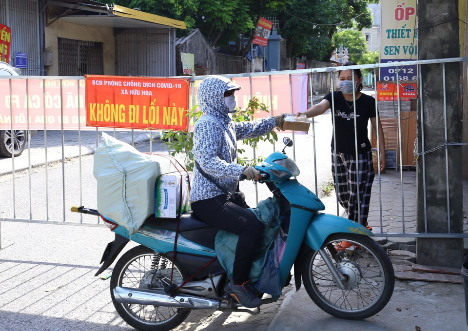 Giao và nhận hàng tại rào chắn tổ 12, Mậu Lương (Kiến Hưng, Hà Đông). (Ảnh: Hoàng Hiếu/TTXVN)