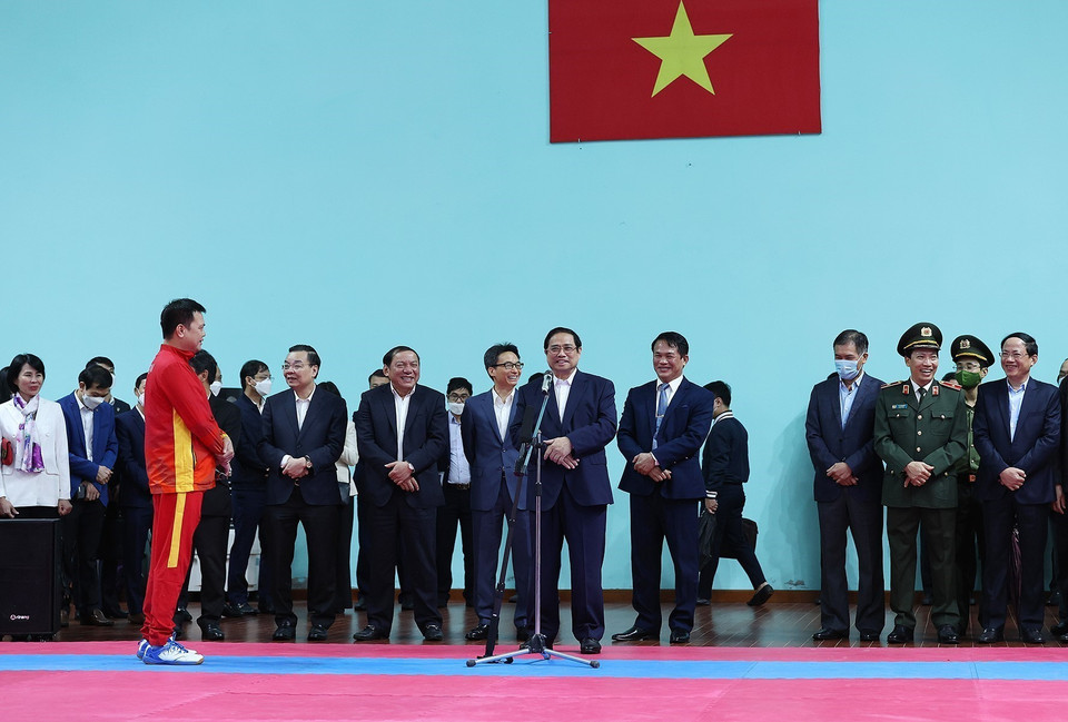 Thủ tướng Phạm Minh Chính động viên các huấn luyện viên và vận động viên đang tập luyện chuẩn bị tại Trung tâm Huấn luyện thể thao quốc gia. (Ảnh: Dương Giang/TTXVN)
