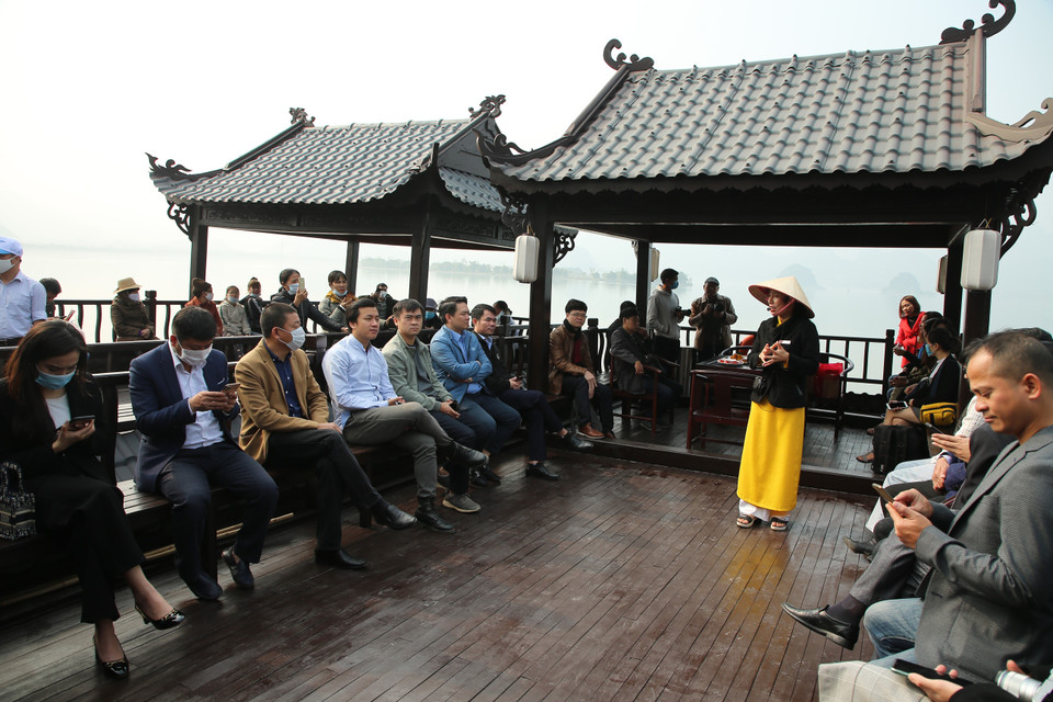 Du khách thích thú vừa trải nghiệm đi thuyền trên đầm vừa nghe hướng dẫn viên giới thiệu về sự tích và kiến trúc chùa Tam Chúc. (Ảnh: Xuân Mai/Vietnam+)