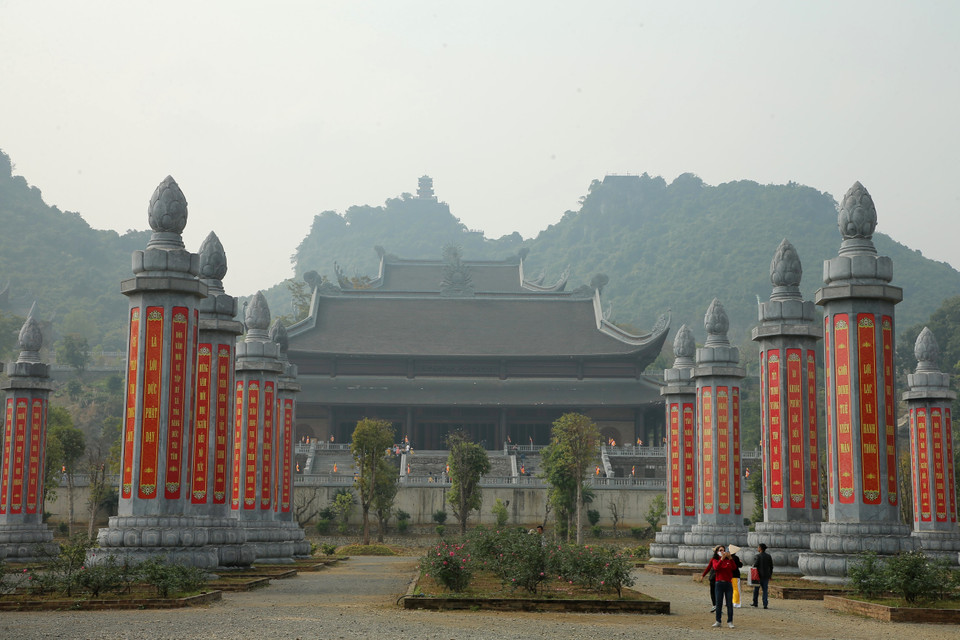 Vườn cột kinh đồ sộ nằm ngay sau cổng Tam quan. Đây là là những cột kinh nguyên phục dựng giống Bảo vật quốc gia cột kinh chùa Nhất Trụ ở cố đô Hoa Lư, Ninh Bình. Giữa khoảng sân từ Tam quan tới điện Quan Âm có 32 cột kinh được bằng đá xanh Thanh Hóa, cao 13,5m, rộng khoảng 2m, mỗi cột nặng khoảng 200 tấn. Những lời Phật dạy được khắc lên những cột kinh này để nhắc nhở thế hệ hiện tại cũng như mai sau tu nhân tích đức. (Ảnh: Xuân Mai/Vietnam+)