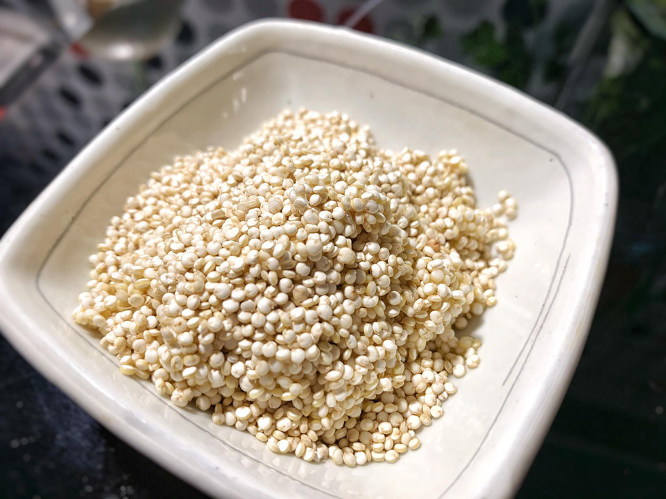 Hạt Qiunoa (còn gọi là hạt diêm mạch), có nguồn gốc từ Nam Mỹ, giống ngũ cốc nhưng không thuộc họ cây ngũ cốc mà chung họ với rau bina và củ cải đường. Loại hạt này màu xám trắng giống hạt kê, có hương thoang thoảng mùi hạt dẻ kết hợp với mùi lúa mạch và ngô non. Hạt Quinoa là loại hạt duy nhất cân bằng được các hợp chất như đường, protein và chất xơ mà không cần đến Gluten (loại Protein gây khó tiêu) nên thường được phục vụ trong bữa ăn của các phi hành gia, có tác dụng ổn định đường huyết, ngừa tim mạch... Bên cạnh đó, loại hạt này cũng chứa rất nhiều dưỡng chất như canxi, magie, sắt, chất xơ, axit amin,… rất tốt cho việc làm đẹp và làm thực phẩm hằng ngày. (Ảnh:Vietnam+)