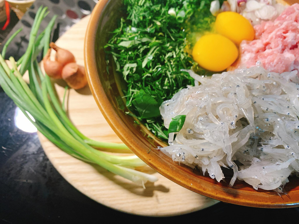 Các loại rau gia vị đem thái chỉ, trút vào thố cùng cá, thịt và trứng. (Ảnh: Đậu Đậu/Vietnam+)