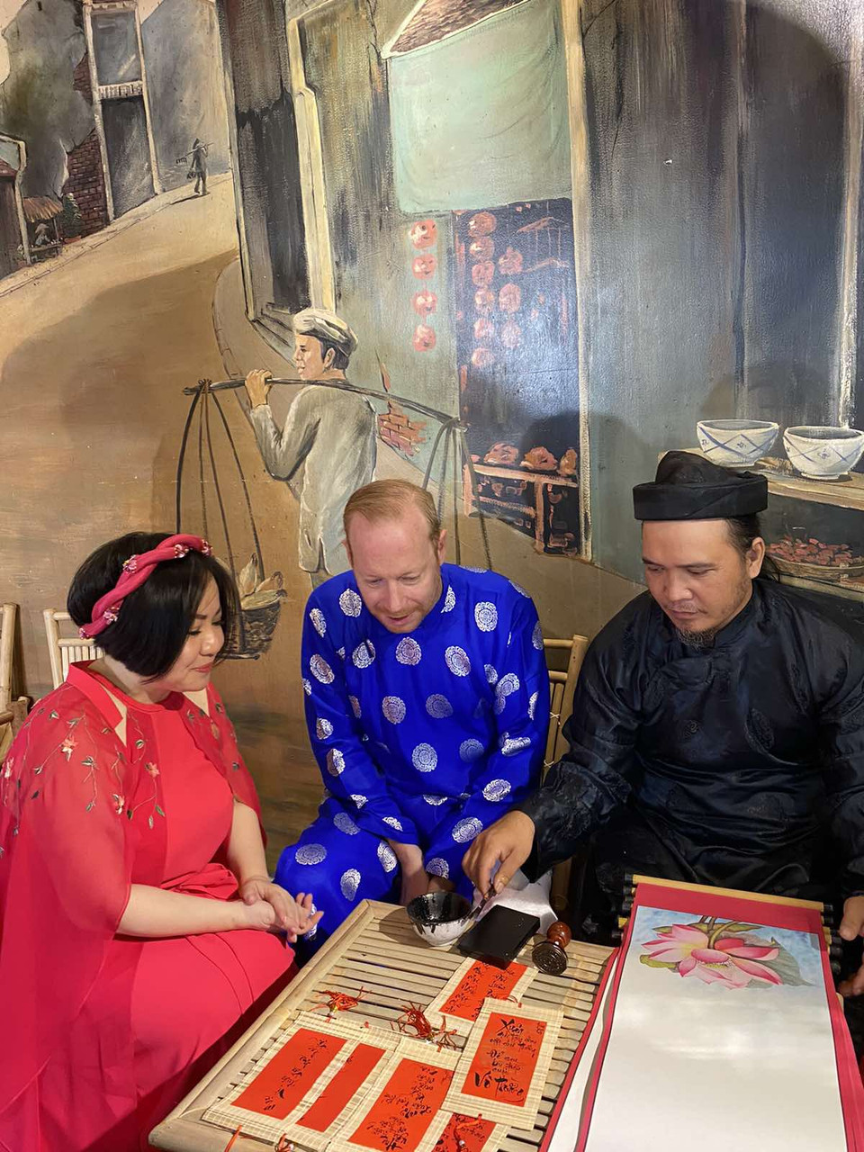 Khách mời trải nghiệm phong tục cho chữ đầu Xuân mới của người Việt. (Ảnh: Vietnam+)