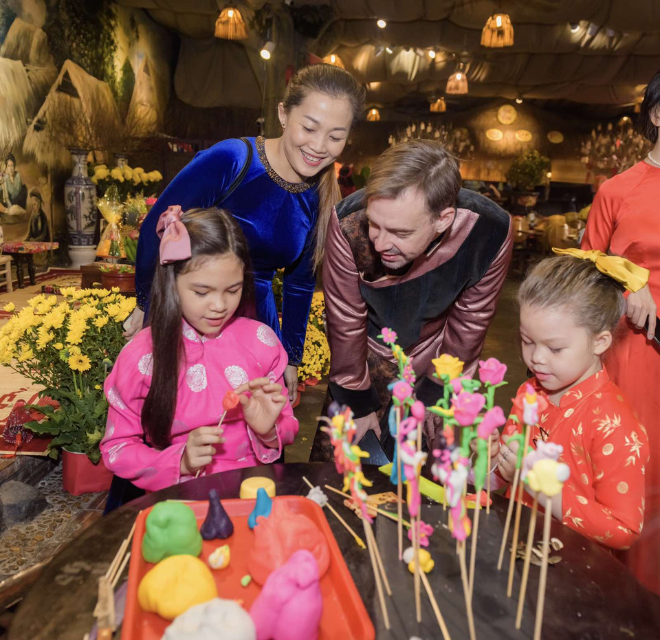 Không chỉ người lớn mà các em bé ngoại quốc cũng vô cùng thích thú khi được chứng kiến tận mắt các nghệ nhân nặn tò he tạo hình hàng trăm tác phẩm đầy màu sắc và sống động. (Ảnh: Vietnam+)