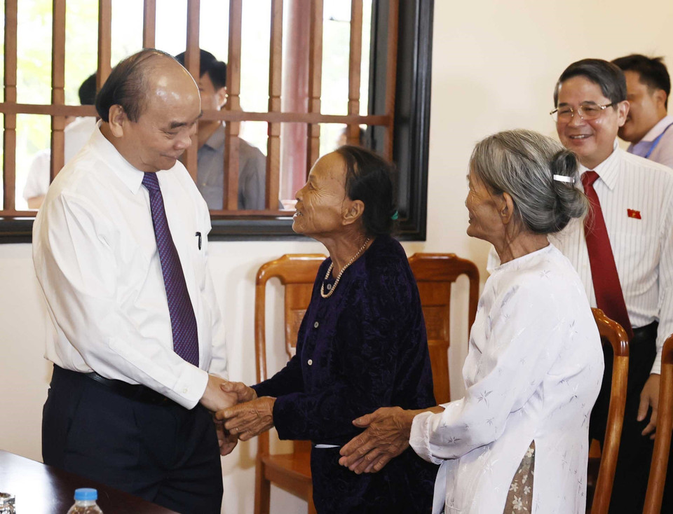 Chủ tịch nước Nguyễn Xuân Phúc thăm hỏi đại diện các hộ gia đình người có công với cách mạng thôn Khương Mỹ, xã Tam Xuân 1, huyện Núi Thành. (Ảnh: Thống Nhất/TTXVN)