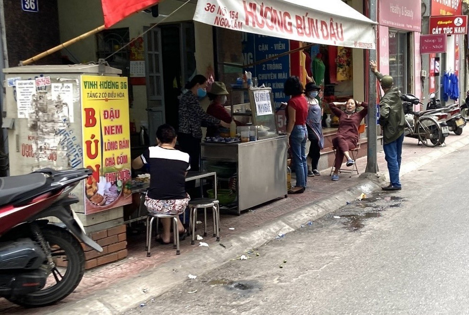 Các hàng quán tại phố Ngọc Lâm (quận Long Biên, Hà Nội) lấn chiếm vỉa hè để bán cho khách. (Ảnh: Minh Nghĩa/TTXVN) 