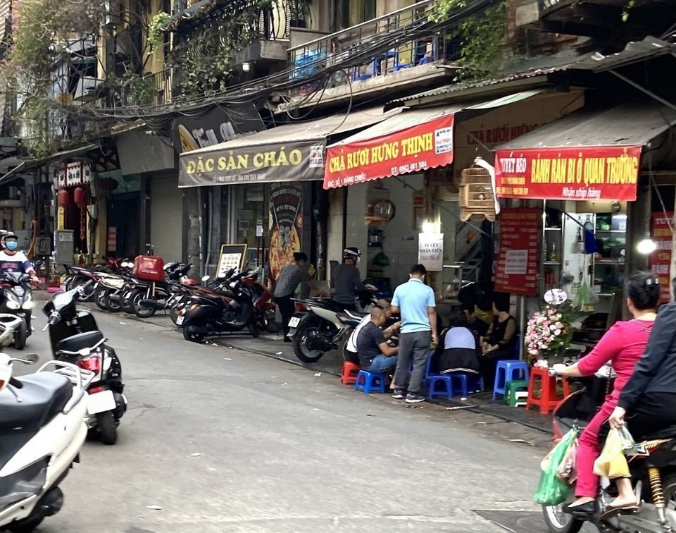 Người dân và cả người bán không tuân thủ giãn cách, bày bàn ghế ra vỉa hè tại phố Hàng Chiếu (quận Hoàn Kiếm). (Ảnh: Minh Nghĩa/TTXVN)