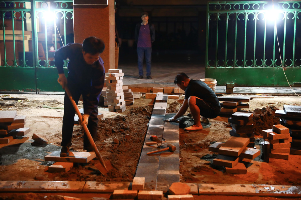 Công nhân xây dựng tập trung làm vỉa hè phố Trần Nguyên Hãn, quận Hoàn Kiếm lúc 0h52' ngày 26/11. (Ảnh: Hoàng Hiếu/TTXVN)
