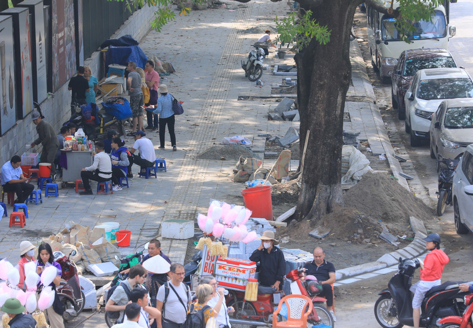 Vật liệu, phế liệu xây dựng để tràn lan, hàng quán lấn chiếm vỉa hè gây mất mỹ quan đô thị, đoạn trước Bảo tàng Dân tộc học trên phố Nguyễn Văn Huyên, quận Cầu Giấy. (Ảnh: Hoàng Hiếu/TTXVN)